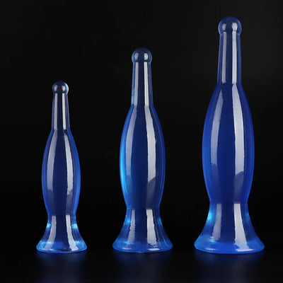 Three crystal blue bottle-shaped anal dildo plugs standing upright on black background